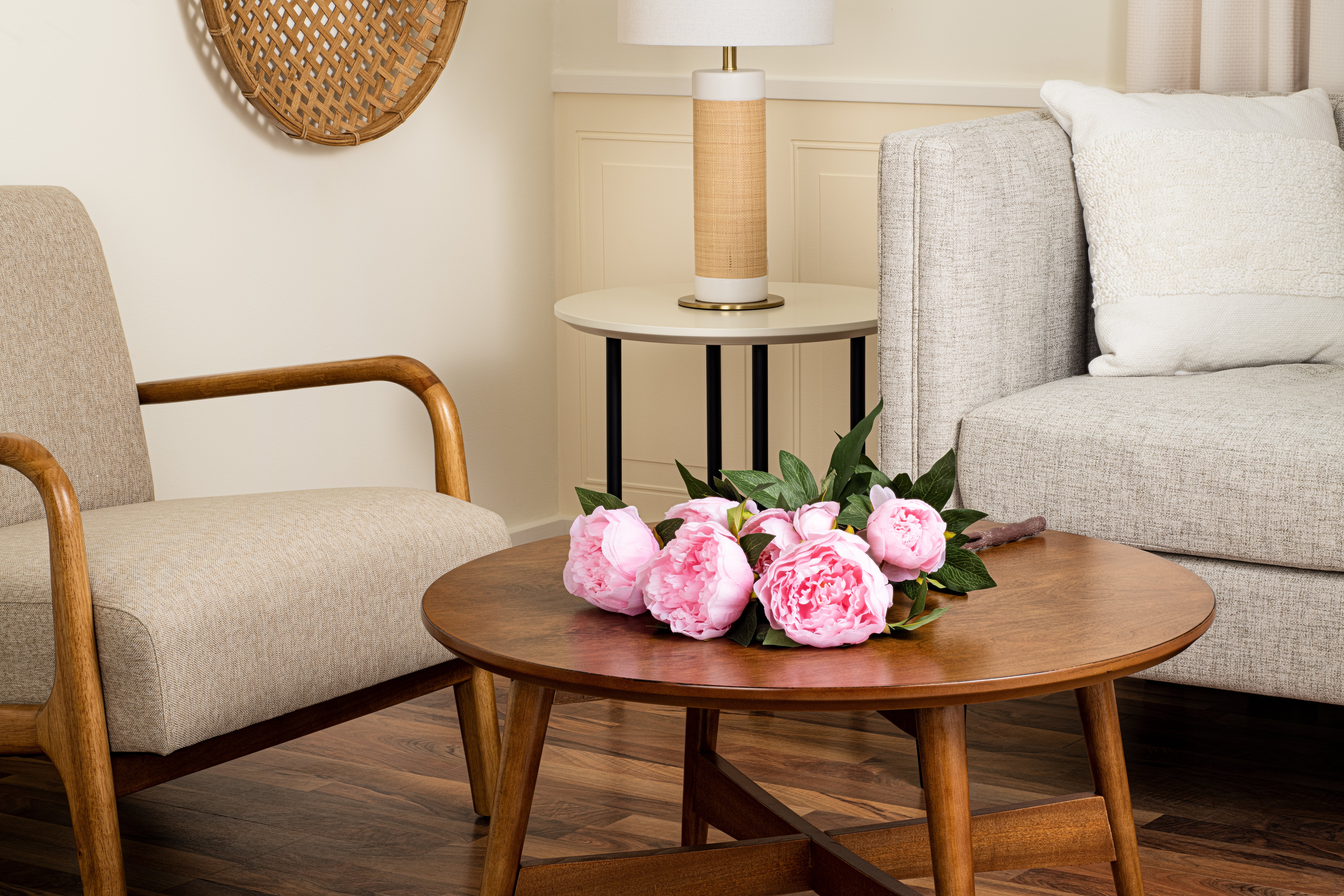 Faux pink flowers lay on wood coffee table in living room
