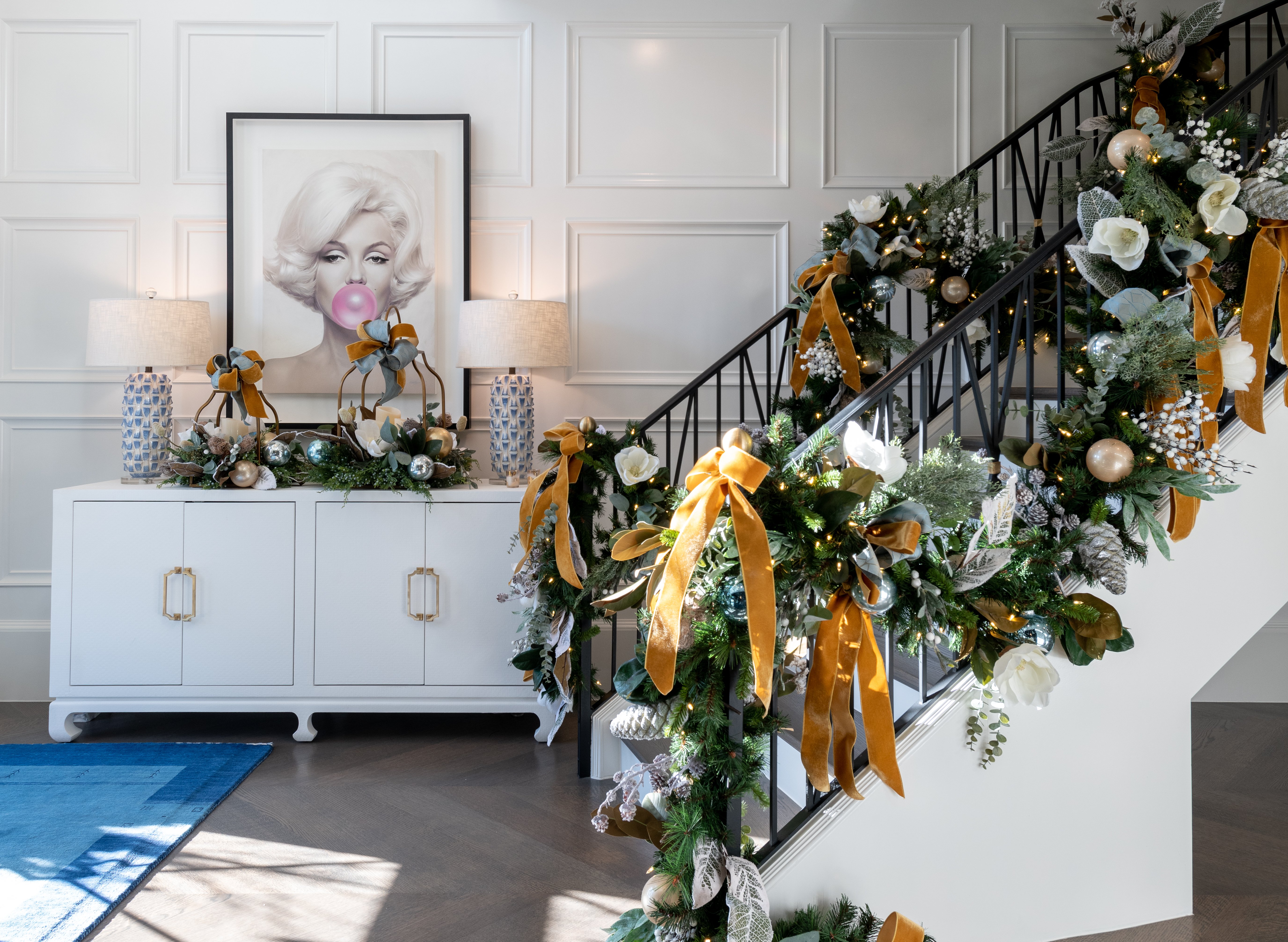 Staircase adorned with greenery and yellow ribbons in home entryway